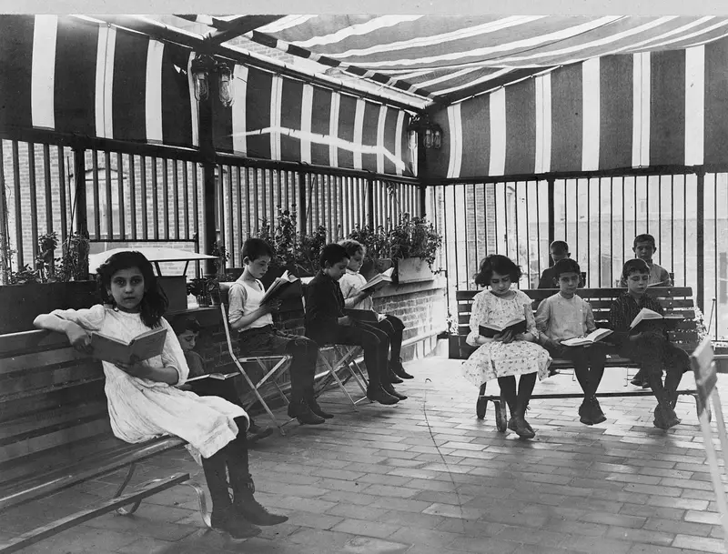 Children reading on benches in a roof garden library, New York, 1919